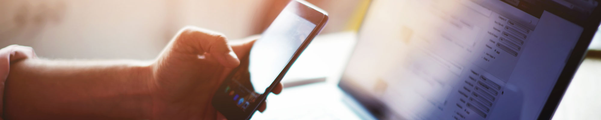 Man using laptop and mobile phone